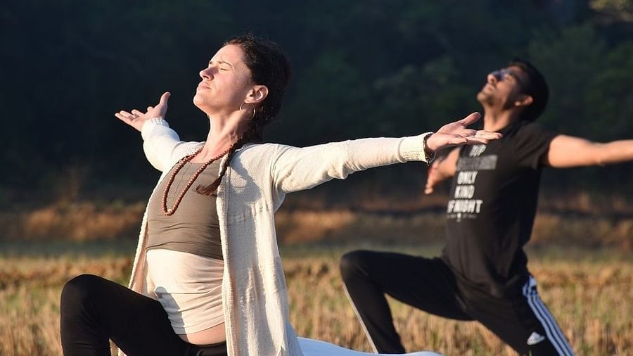Two people performing a yoga pose - Evergreen County