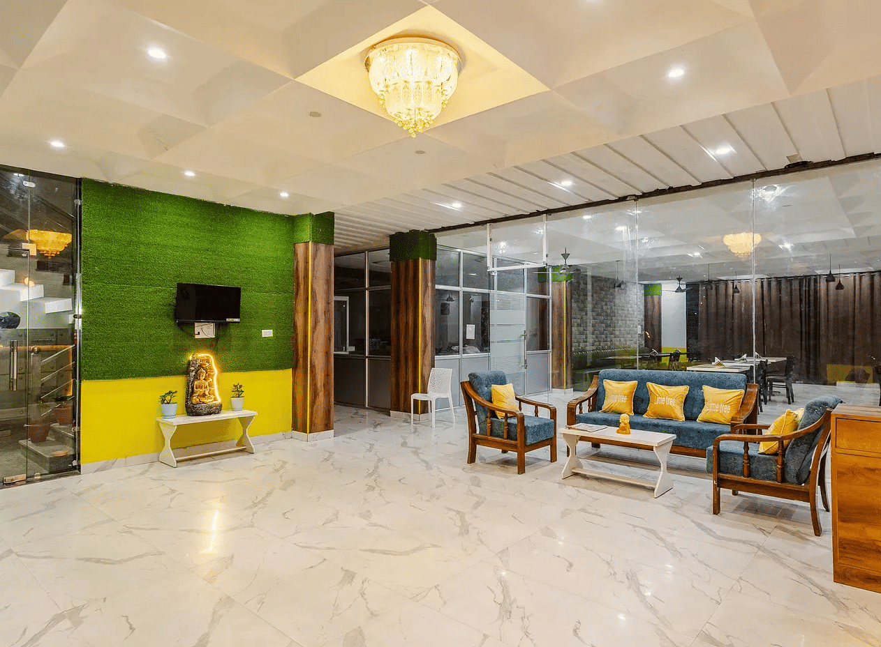 A hotel lobby with seating area, green accent wall, and chandelier lighting - Lime Tree Hotels & Banquet, Vrindavan