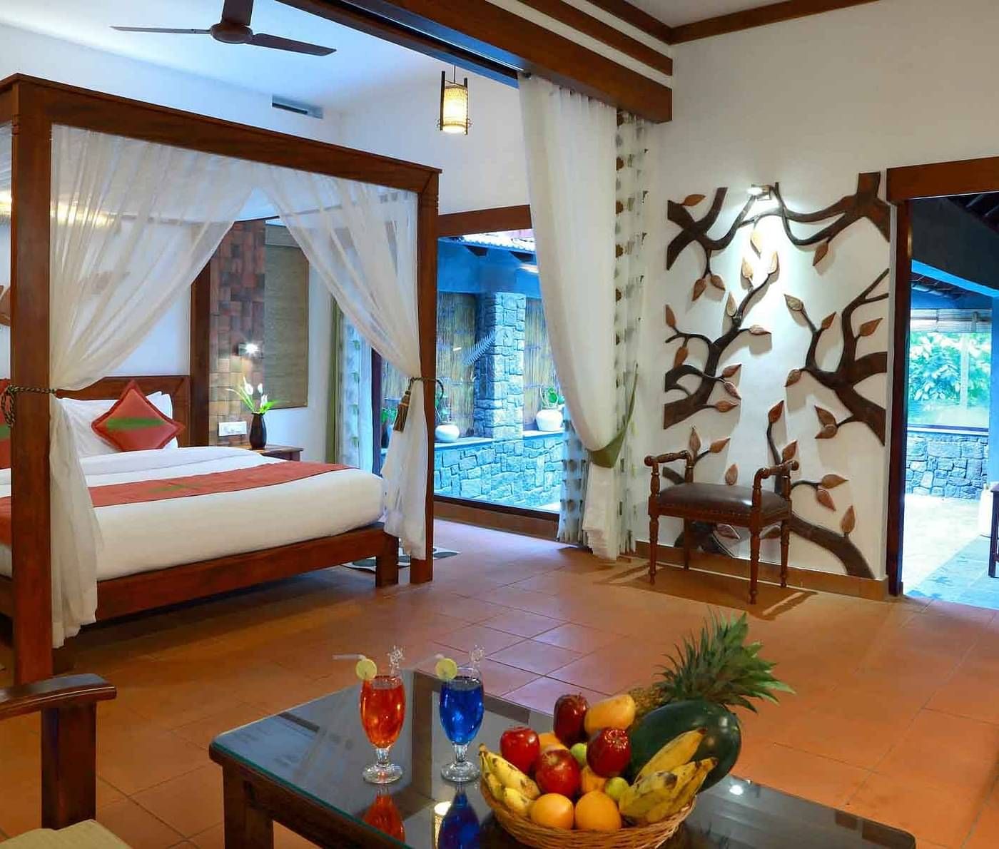 Room with a four-poster bed and seating area at Vythiri Resort, Wayanad