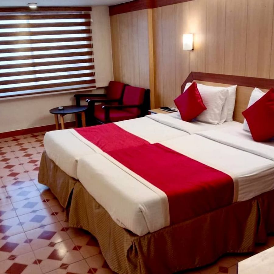 Room with double bed, work station, and a seating area at Hotel Swagath, Bangalore
