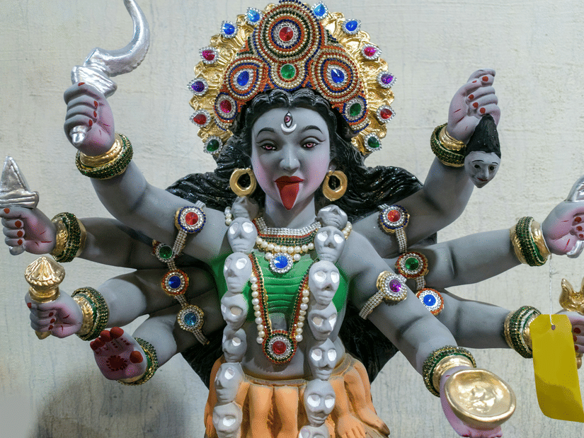 An overview of the idol of Goddess Kali with her many hands holding many items.