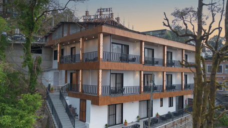 A beautiful facade of the Perfectstayz Premium Westend Mall Road, Mussoorie, featuring a 3-storey building with balconies.