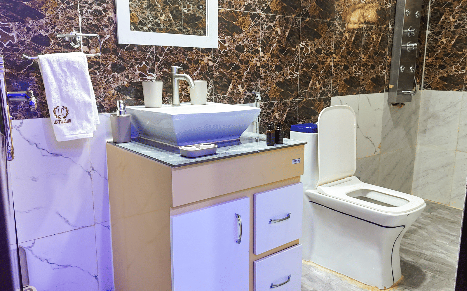 Modern bathroom interior with a wooden vanity, sink, water closet, and textured wall finish - Luffu Club