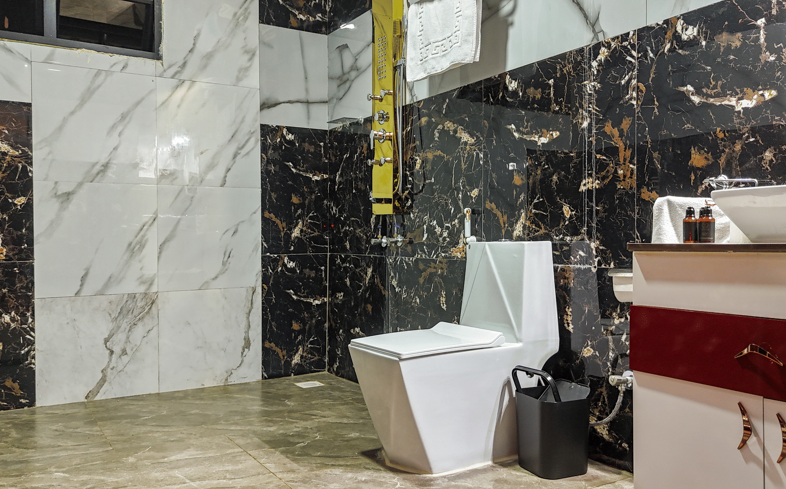 Interior view of a modern bathroom with marble-style tiling, a water closet, and a sink vanity - Luffu Club