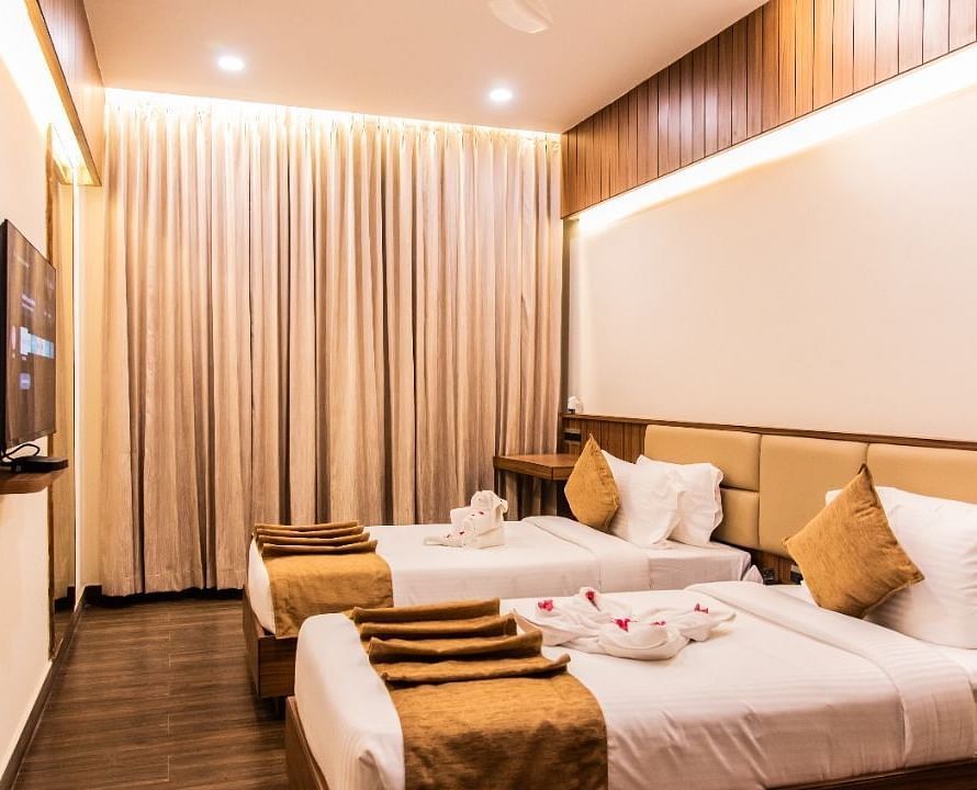 Executive room with two beds and television at TGI Felicity
