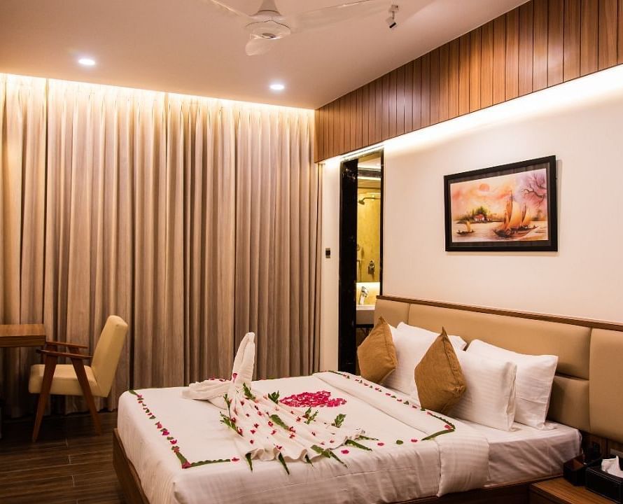 Room with plush bed decked with table and chair at TGI Felicity