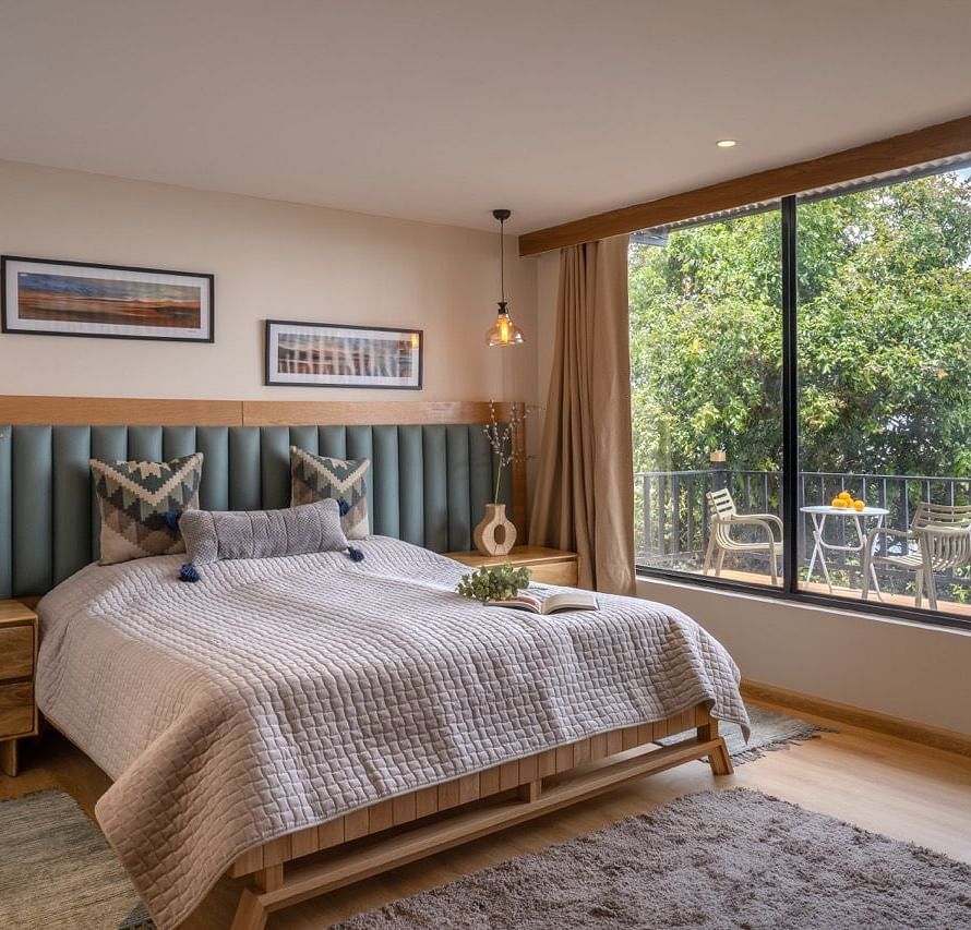 An image of a bedroom with king size bed and a huge window at avalon cottages with side tables