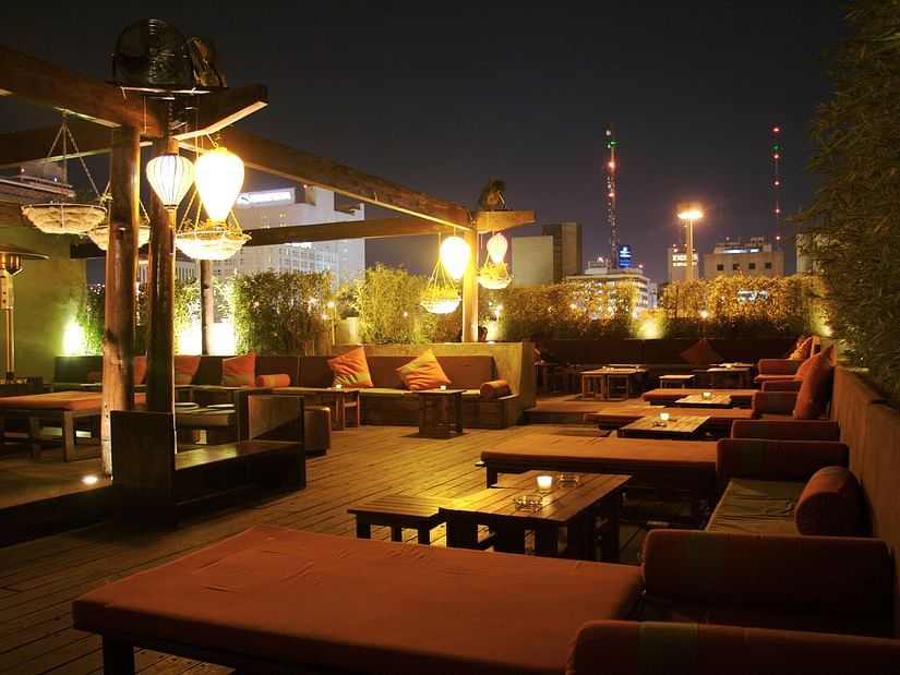 A rooftop restaurant featuring a bunch of tables and chairs