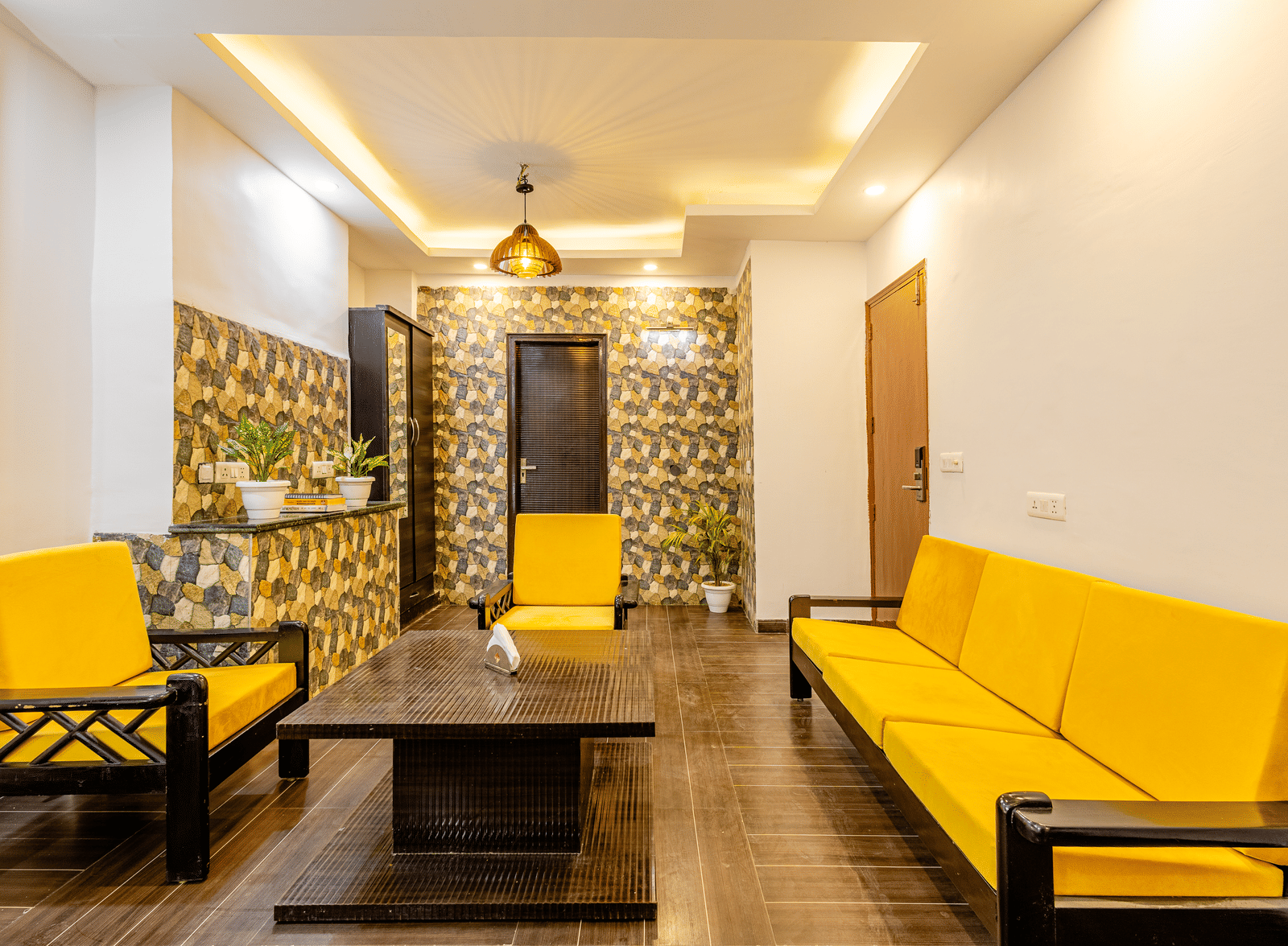 Seperate living room with yellow sofa setup in the suite at Lime Tree Hotels and Banquet Hall Near Huda Metro, Gurgaon