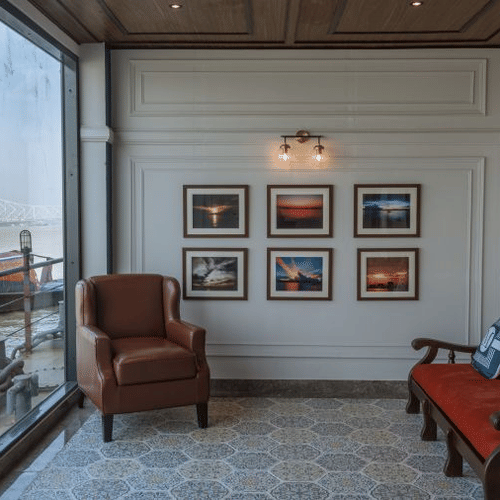 a sit-out with sofas and wall hangings overlooking the river hooghly - polo floatel kolkata