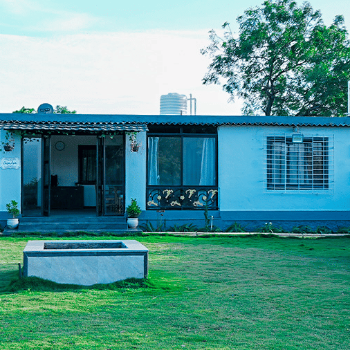 An overview of the FARM-HOUSE with manicured garden in front of it inside Diamond Parks, Pune.