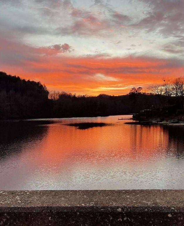a beautiful sunset with hues of orange and sky blue over a pristine lake