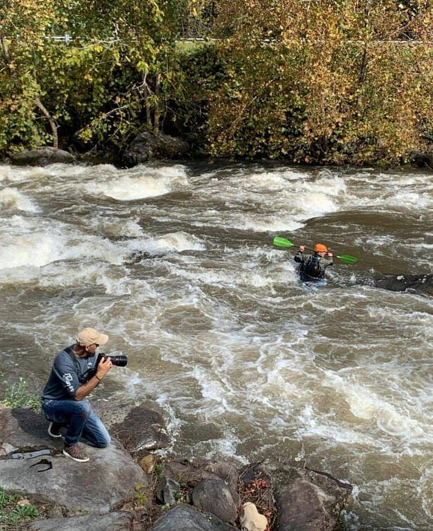 a person clicking photographs with his digital camera on the banks of a river - Historic Tapoco Lodge