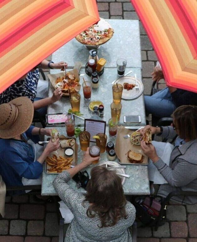top shot of a dining table with four people talking to each other in an open space - Historic Tapoco Lodge