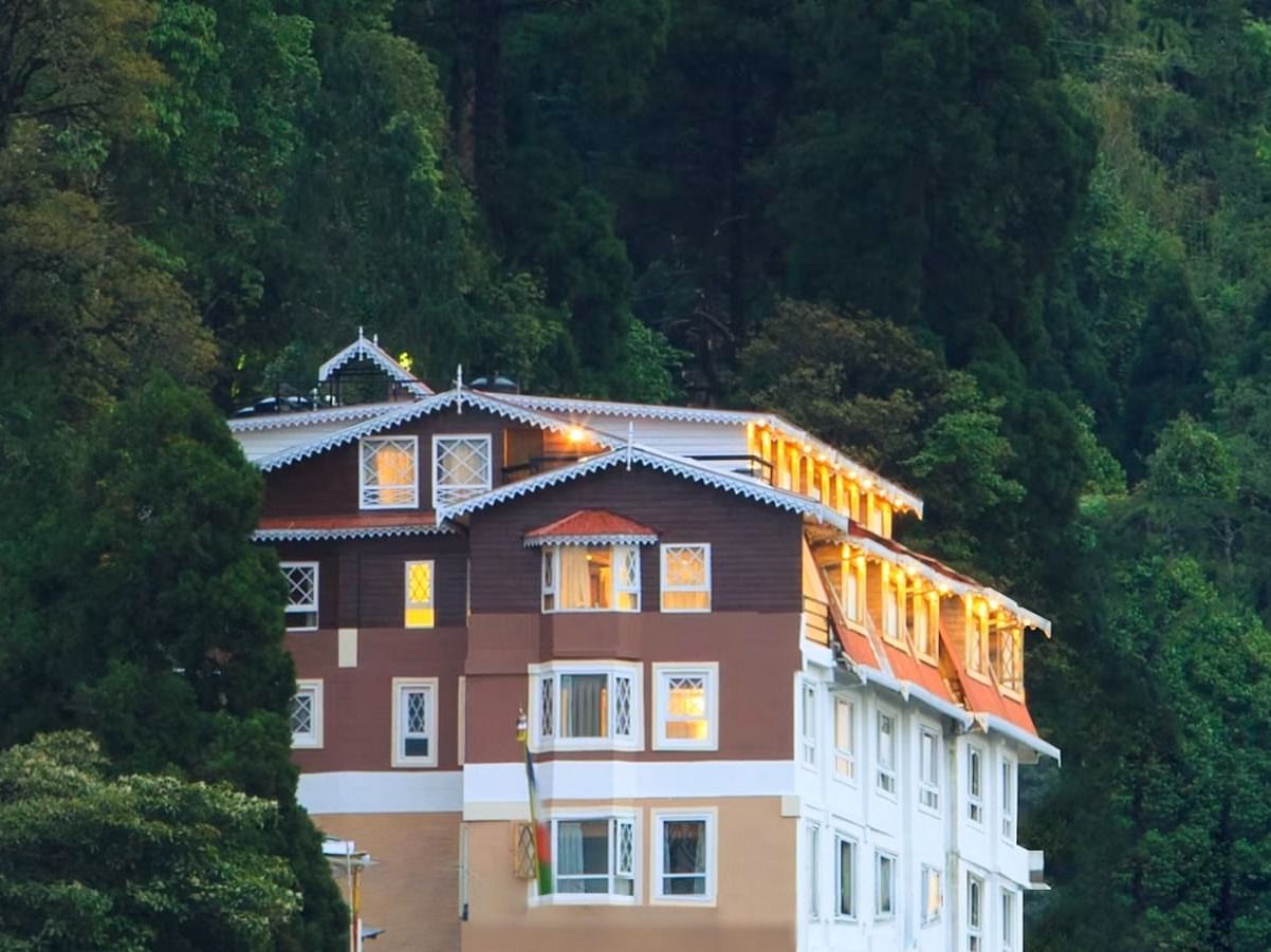 Front facade view of Summit Hermon Hotel & Spa, Darjeeling, surrounded by lush greenery