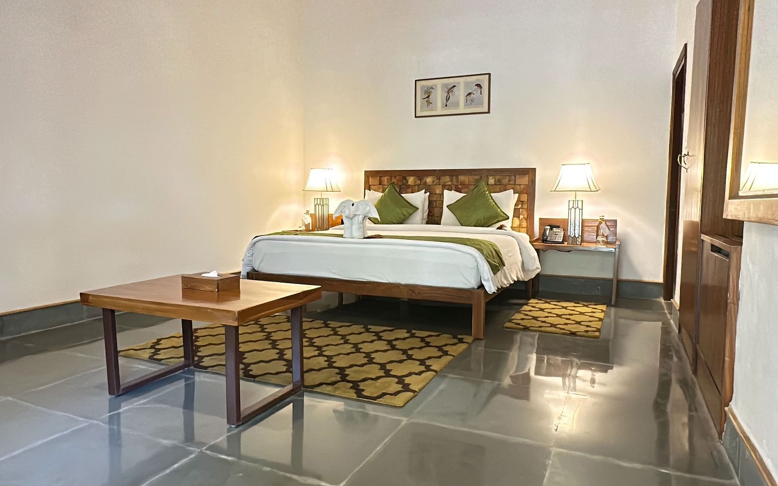 Sanctuary Suite at Saraca Resort & Spa Corbett with a double bed placed in the centre of the room and two side tables adjacent to it