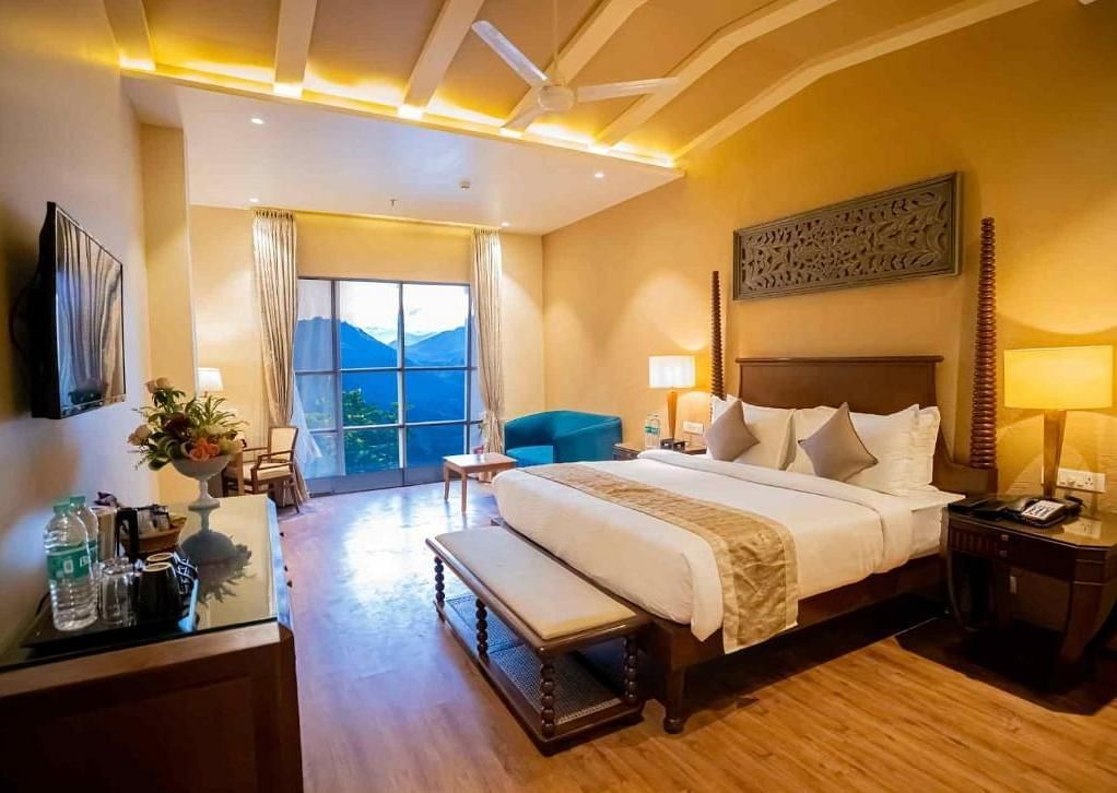 A king size bed placed in front of a TV in a room at Essentia Luxury Resort & Spa, Udaipur.