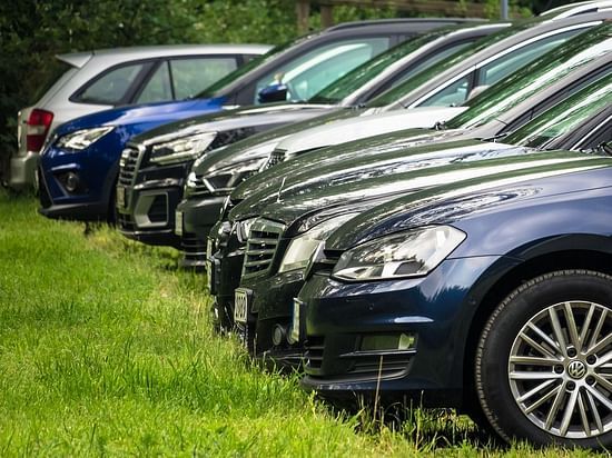 image of a number of cars parked in a lawn with green grass