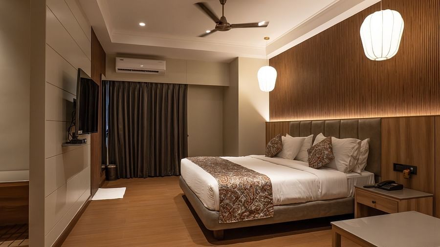 A double bed with a tv in front of it inside super deluxe room - The Cindrella Hotel, Siliguri