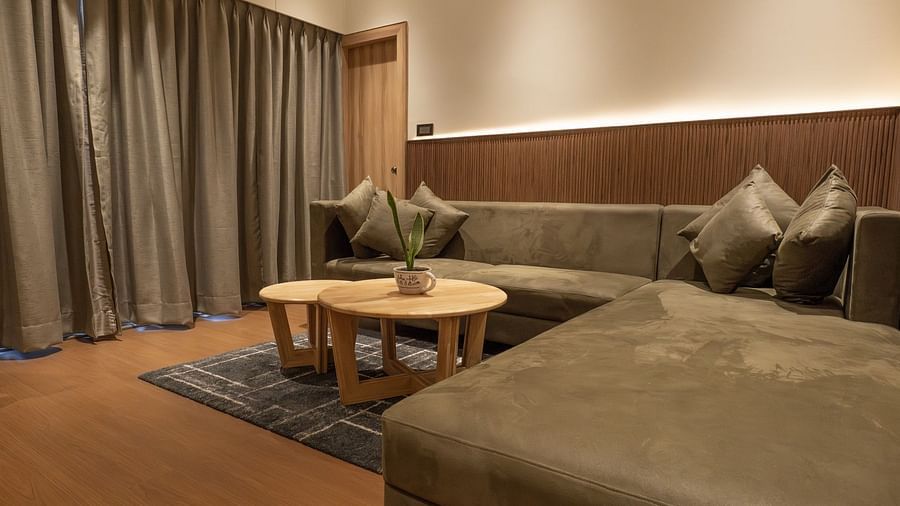 a large L shaped sofa in the living room of the suite - The Cindrella Hotel, Siliguri