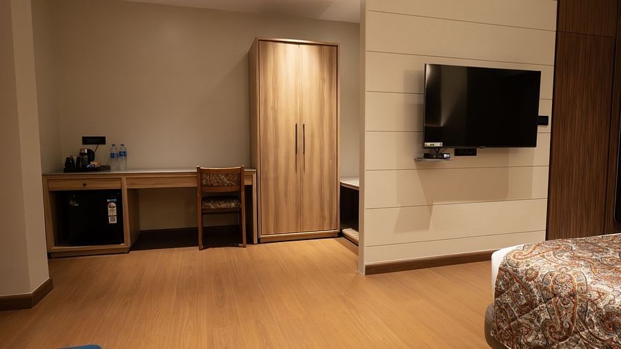 a view of the study table and wardrobe inside super deluxe room - The Cindrella Hotel, Siliguri