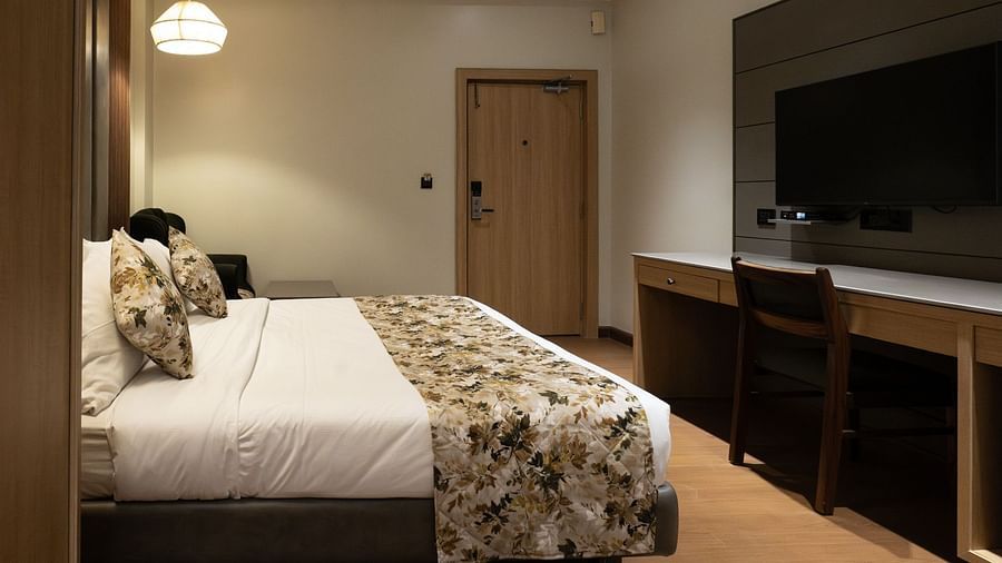 side view of the double bed and tv inside executive room - The Cindrella Hotel, Siliguri