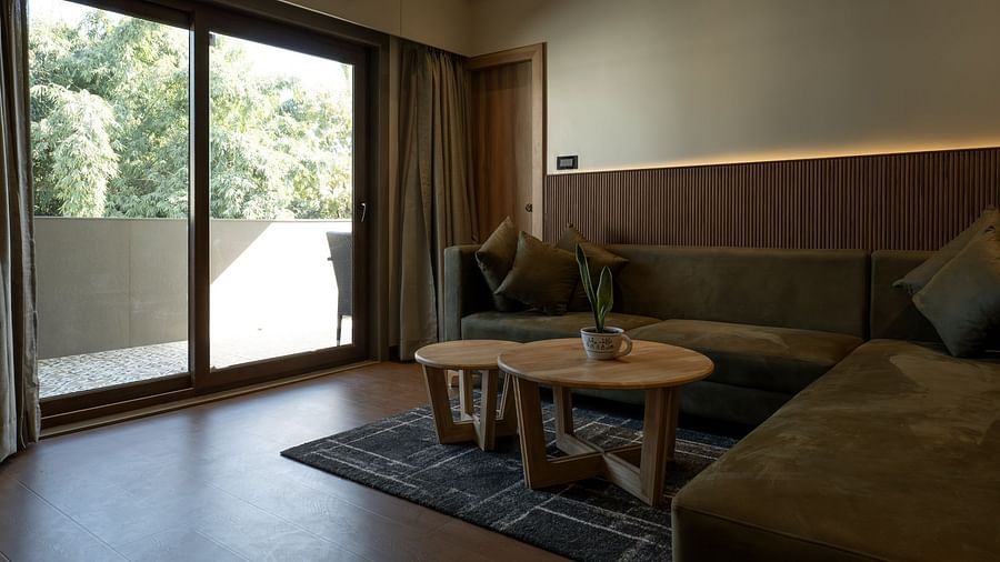 the living area with balcony entrance in view inside the suite - The Cindrella Hotel, Siliguri