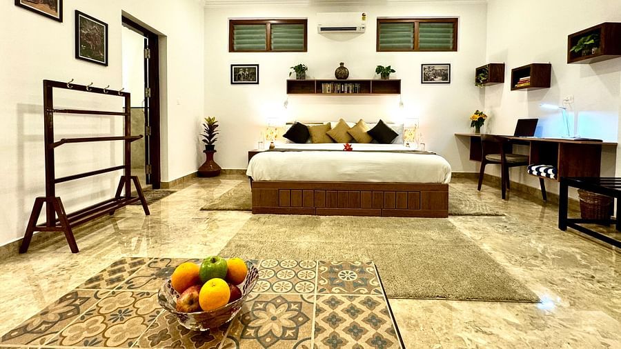 Comfortable bedroom with a double bed, wooden furniture, and decorative wall hangings - BluSalzz Collection - Tranquil Resort, Wayanad