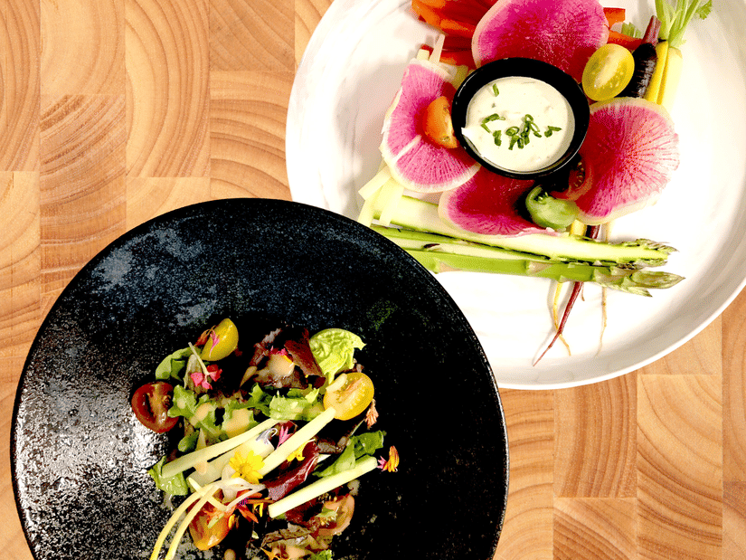 2 platters of well-garnished health foods on a wooden surface at YO1 Longevity and Health Resorts, Catskills.