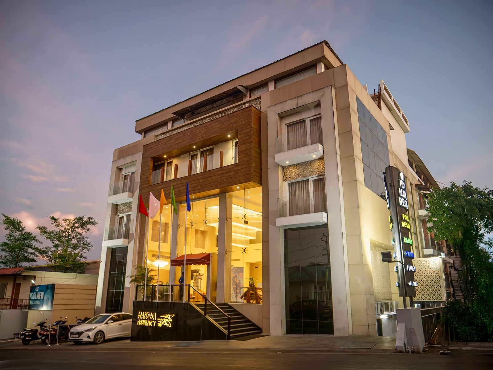 The exterior of Mansha Hotel Regency, a multi-storey building with a modern design, captured during early evening | Mansha Hotels