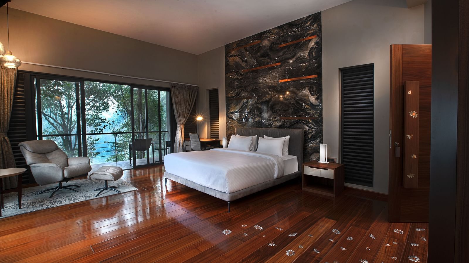 A room featuring a bed and a seating area, complemented by wooden flooring adorned with floral motifs at Stanley Revelation.
