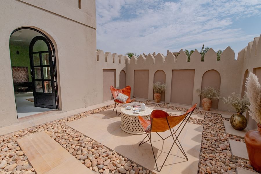 alt-text An image of an outdoor sitout area with chairs and centre table where snacks are kept - Karwaan Jaisalmer