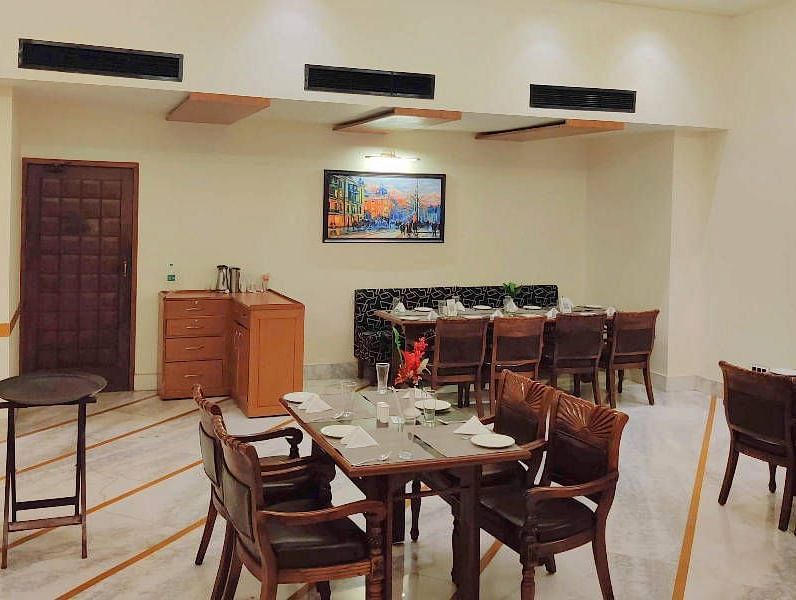 Corner view shot of a brightly lit dining area of the Gold Plate restaurant with central air-conditioning and a small cabinet in the corner of the restaurant - Hotel Gold, Panipat