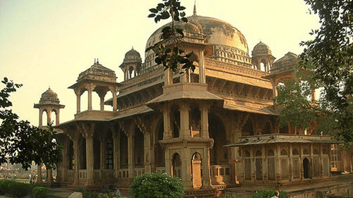 Facade of a brown coloured Tansen tomb during dusk