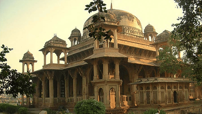 Facade of a brown coloured Tansen tomb during dusk