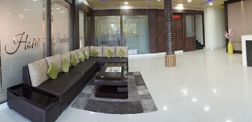 A bright lobby area with stylish black seating, modern décor, and a clean, open layout - Pemaling Lords Eco Inn Guwahati