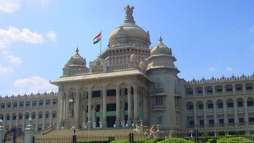 the building of Vidhana Soudha decked in white exterior with a garden laid in front of it