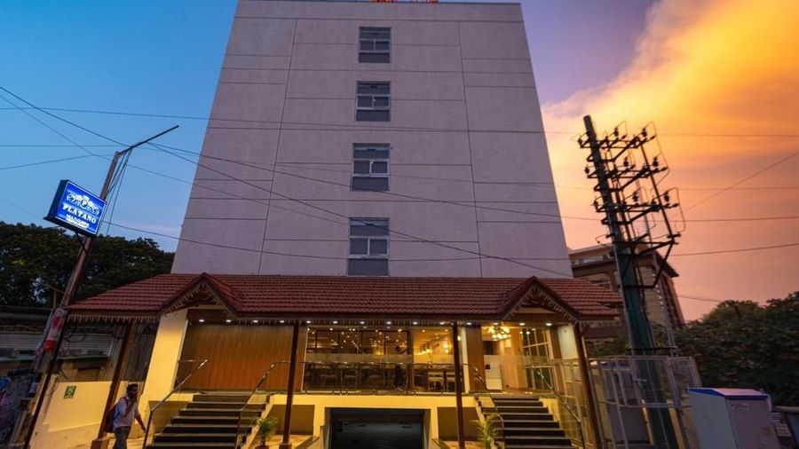 The facade of VITS Select, Bengaluru as seen from the front, featuring stairs leading up to the hotel with a vibrant sky in the background.