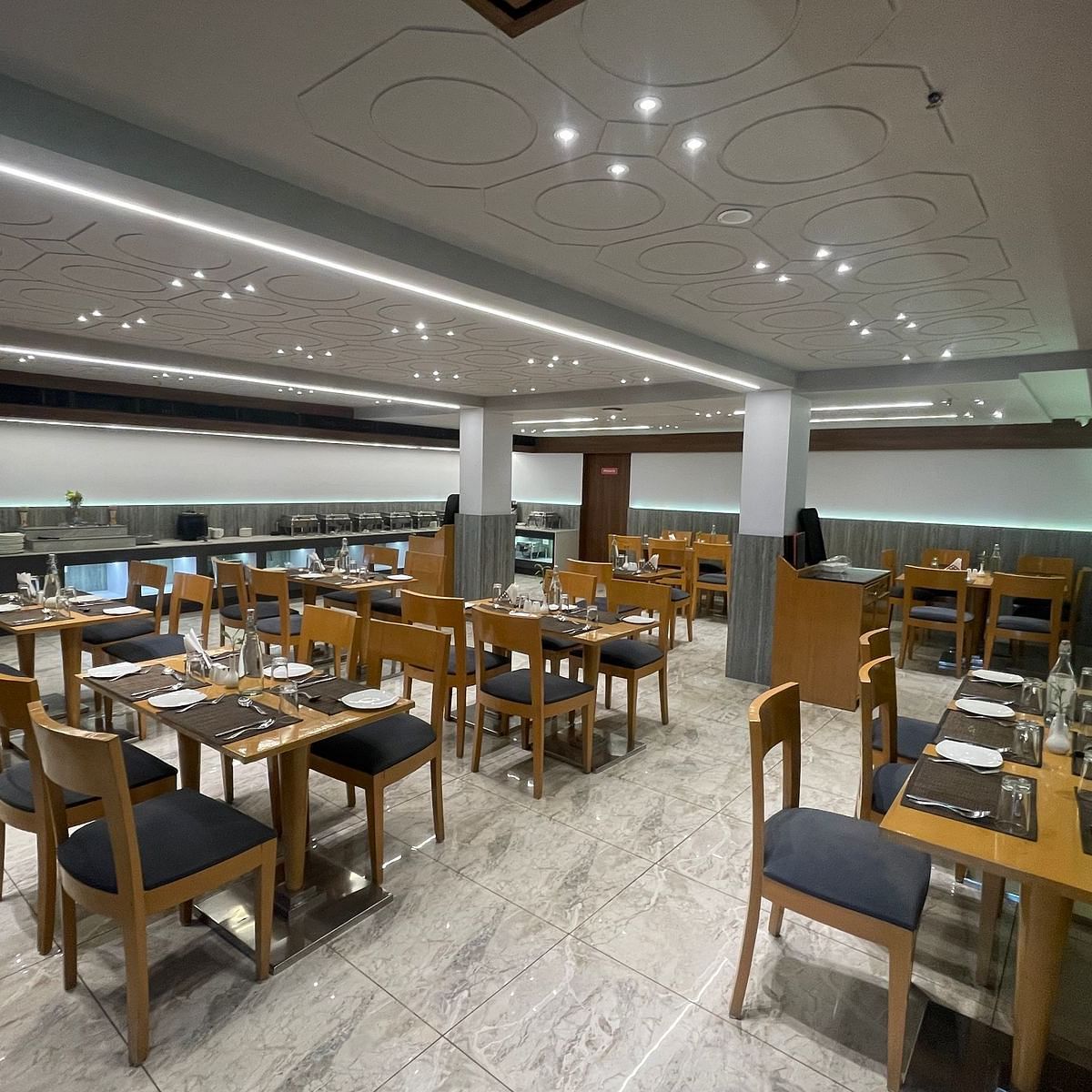 A view of well organised dining hall at Lords Eco Inn Dahej restaurant, featuring a buffet.
