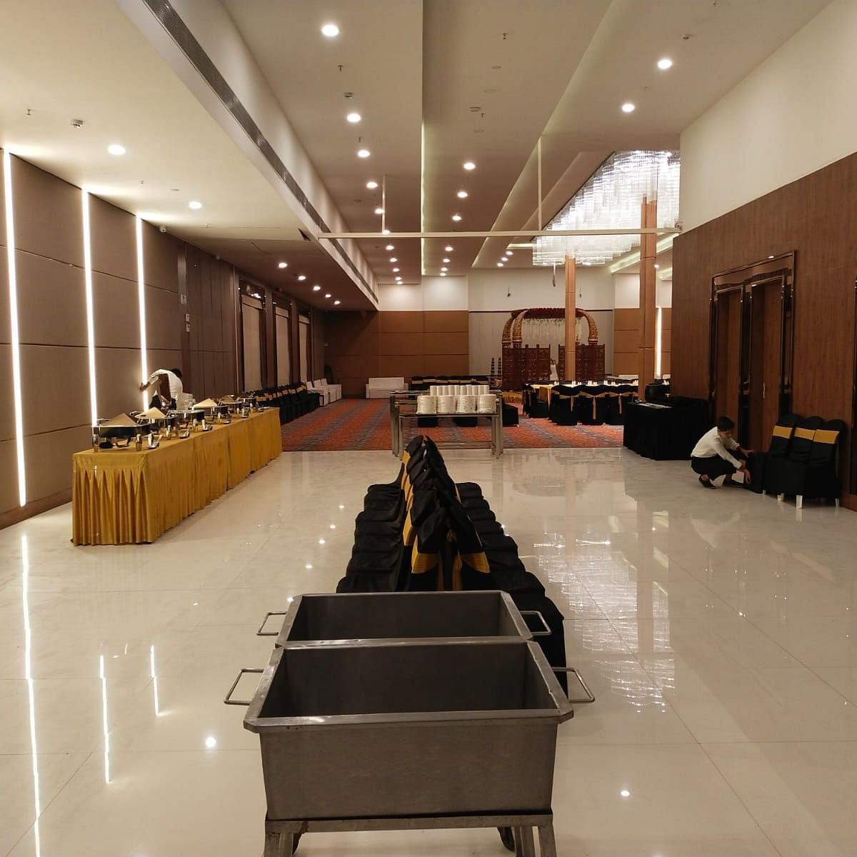 A well-furnished and spacious event room featuring its dining space with buffet stations lined to one side of the room in Lords Eco Inn Shapar Rajkot.