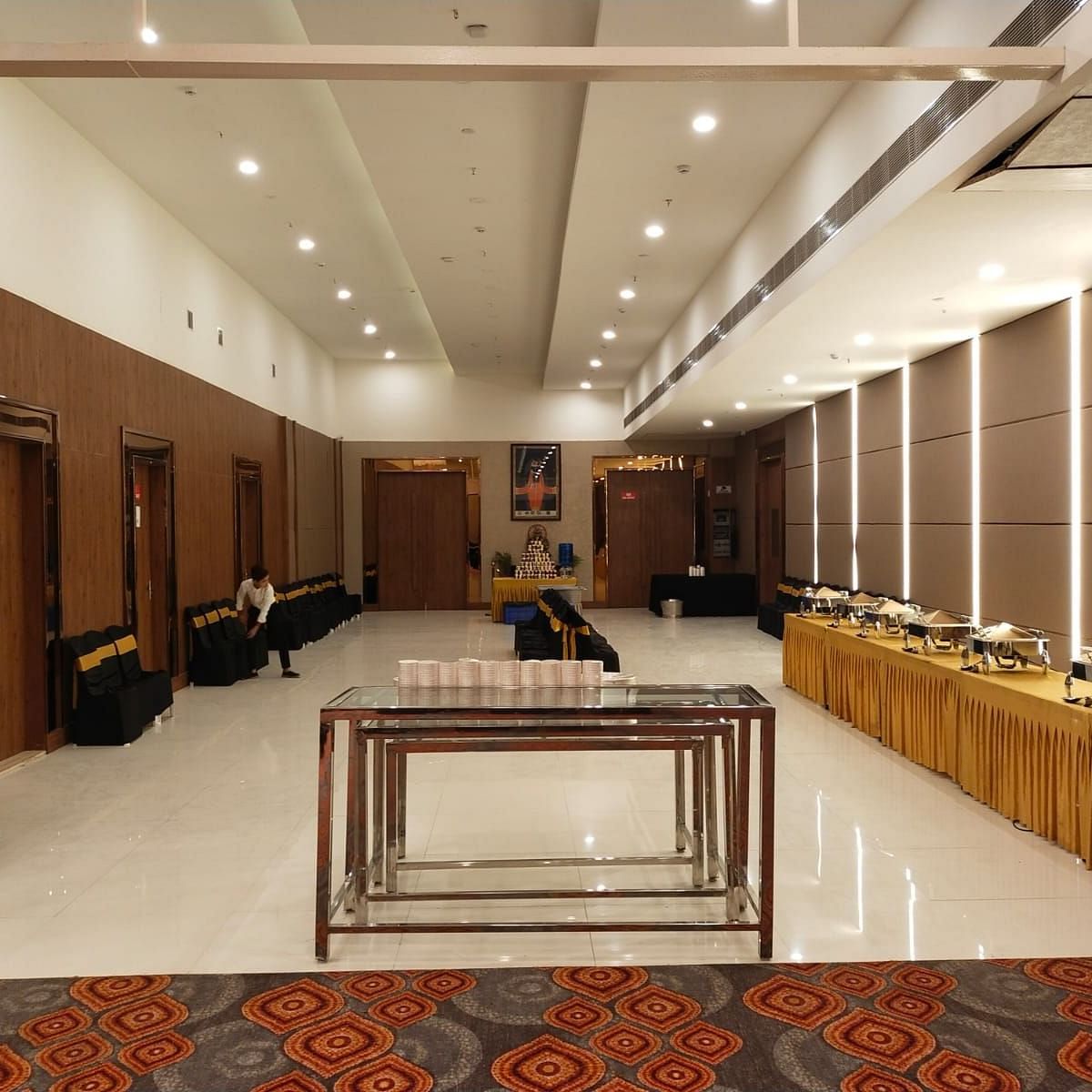 A well-furnished and spacious event room, featuring its dining space with buffet stations lined to one side of the room in Lords Eco Inn Shapar Rajkot.