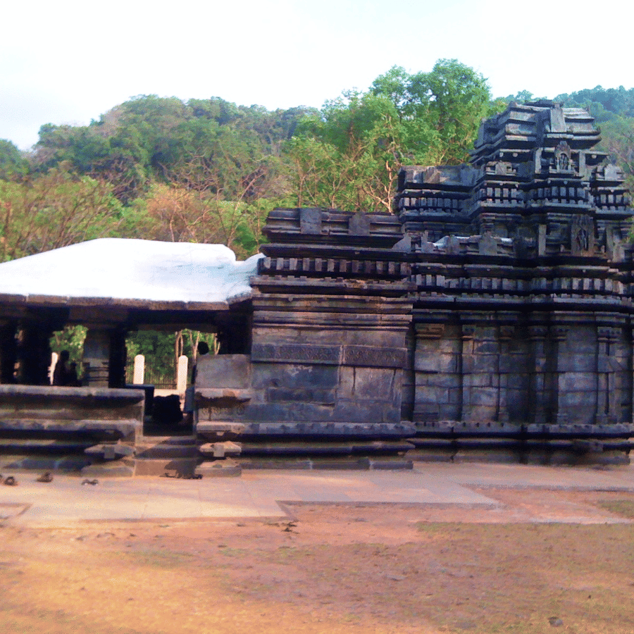 facade view of Shri Mahadev Temple Tambdi Surla with trees in the background