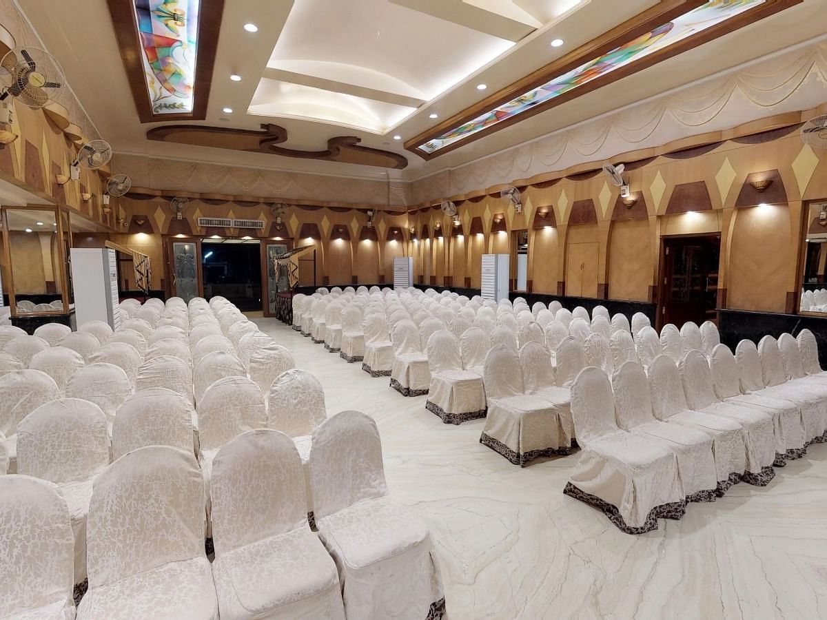 A brightly lit banquet hall at The President Hotel Hubli in threatre style setup