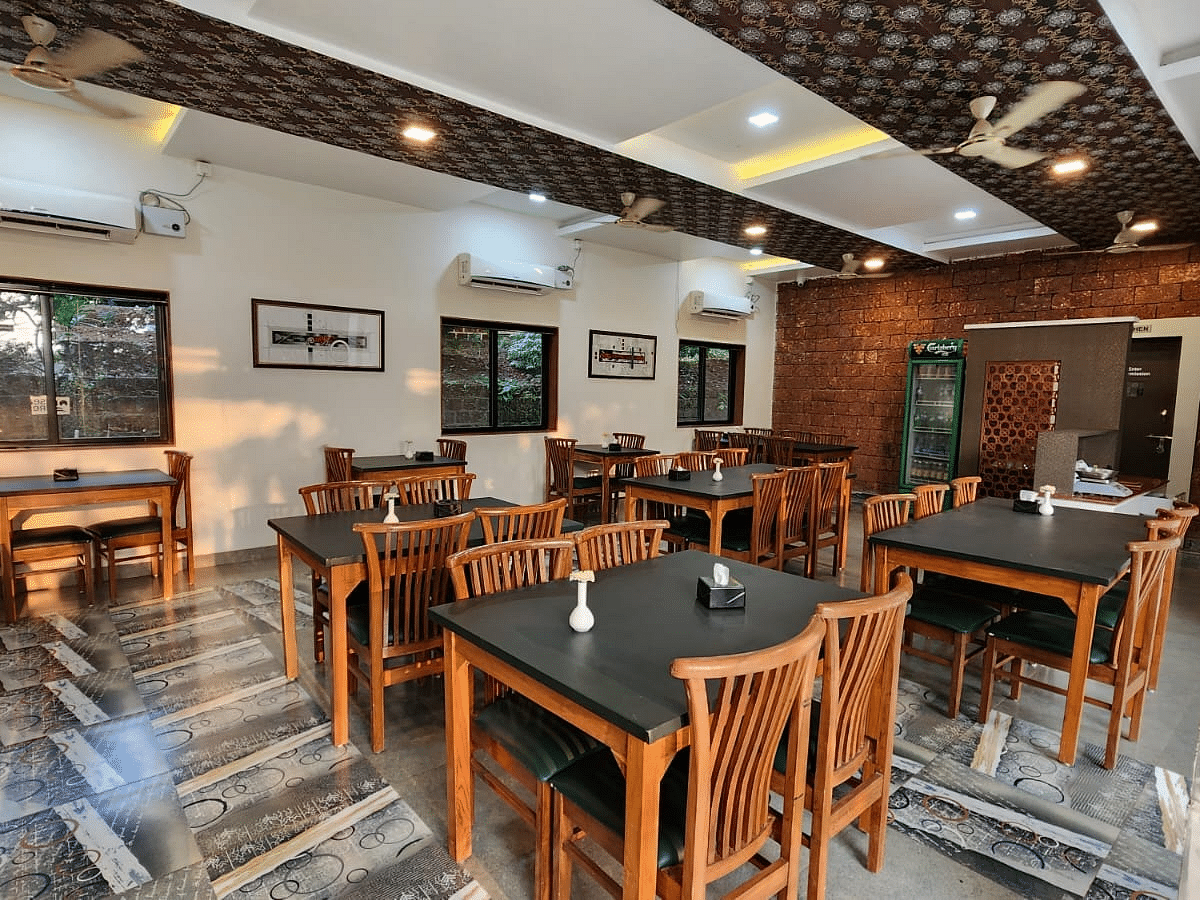 A diagonal view of the restaurant with wooden tables and chairs arranged neatly, and tables set for the guests at SeaFort Beach Resort