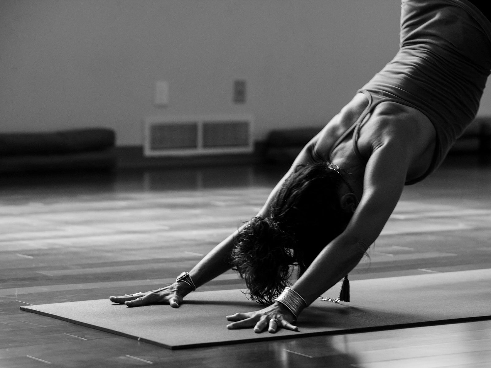 A black and white image of a person performing yoga on a mat - Alibu Resort Nha Trang