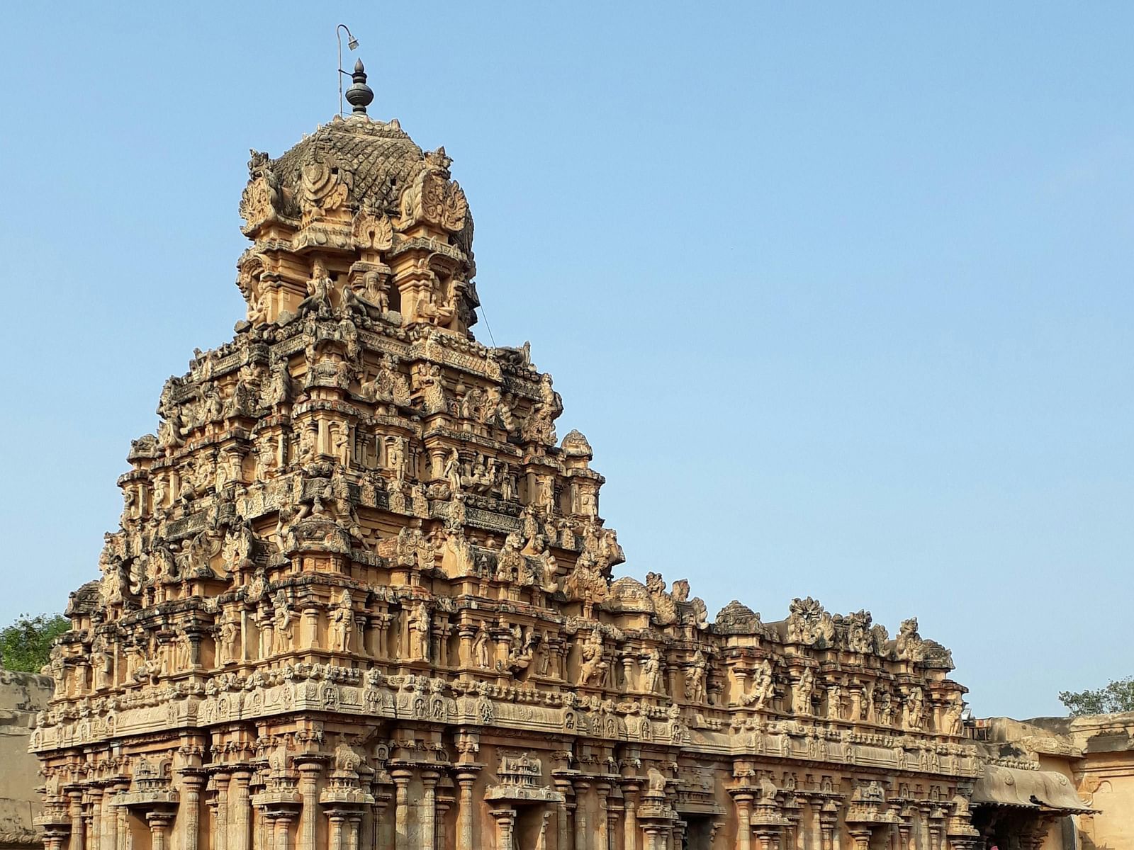 A wide view of the temple featuring intricate stone carvings on the top, showcasing detailed architectural design