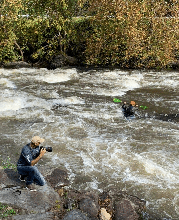 a person clicking photographs with his digital camera on the banks of a river - Historic Tapoco Lodge