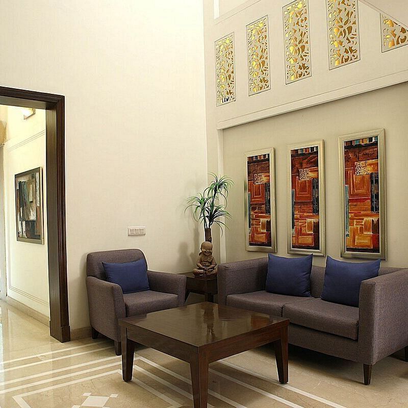 An image of a seating area in a lobby with sofa set and a centre table