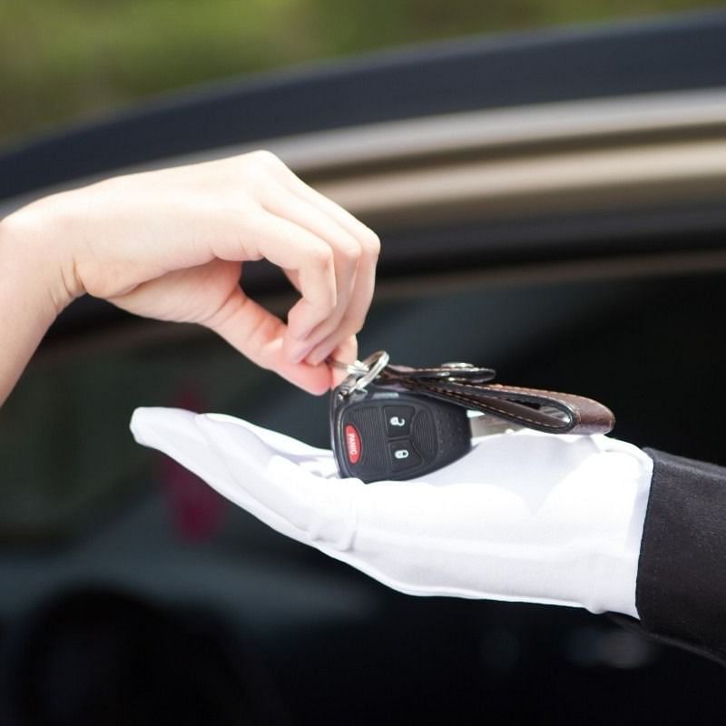 Individual handing key to the valet