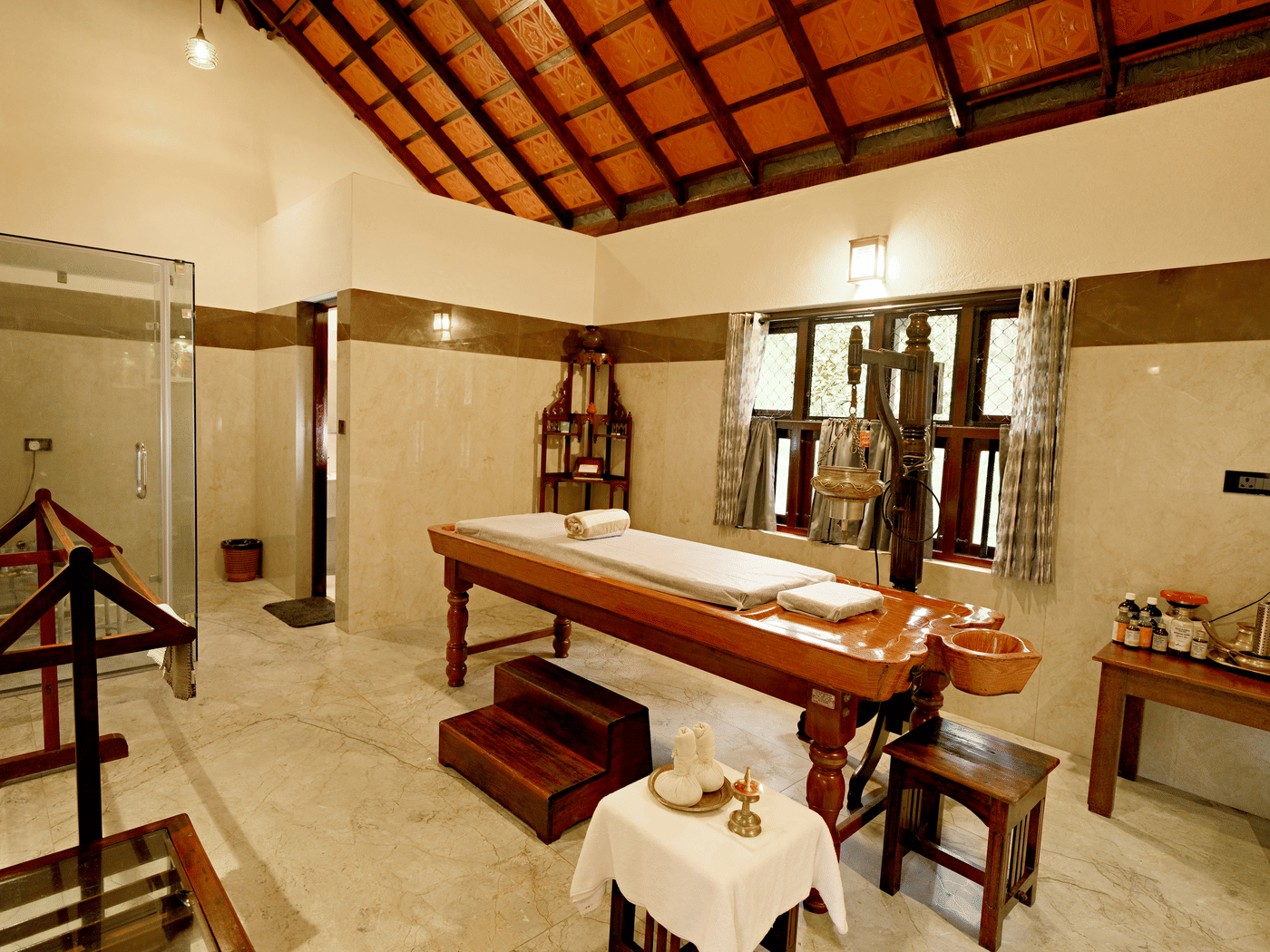 Spa room with massage beds and wooden decor at Vythiri Resort, Wayanad